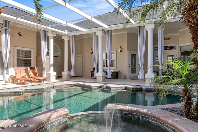 view of swimming pool with an in ground hot tub, glass enclosure, ceiling fan, and a patio area