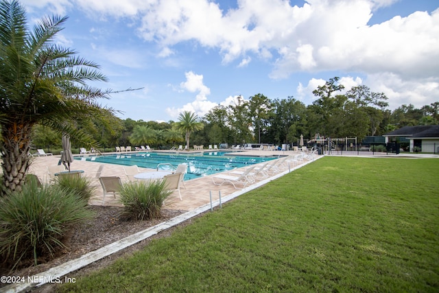 view of swimming pool featuring a yard and a patio area