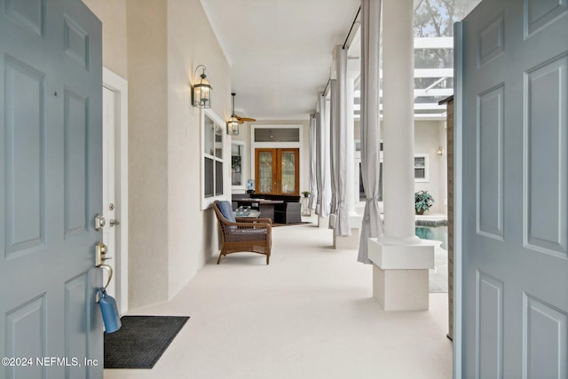 entrance foyer with ceiling fan, french doors, and carpet