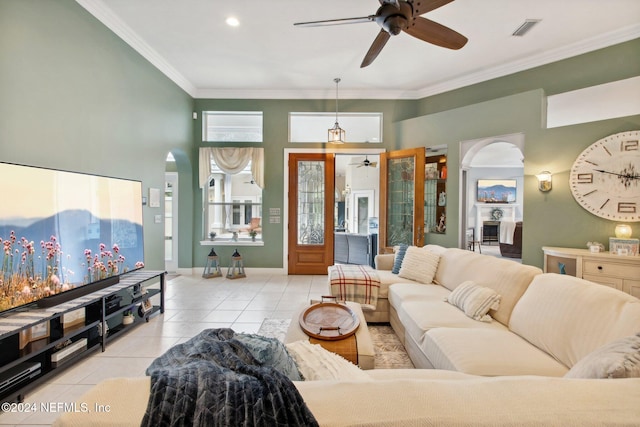 living room featuring light tile patterned floors, ceiling fan, and crown molding