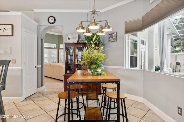 tiled dining area with a chandelier, a wealth of natural light, and ornamental molding