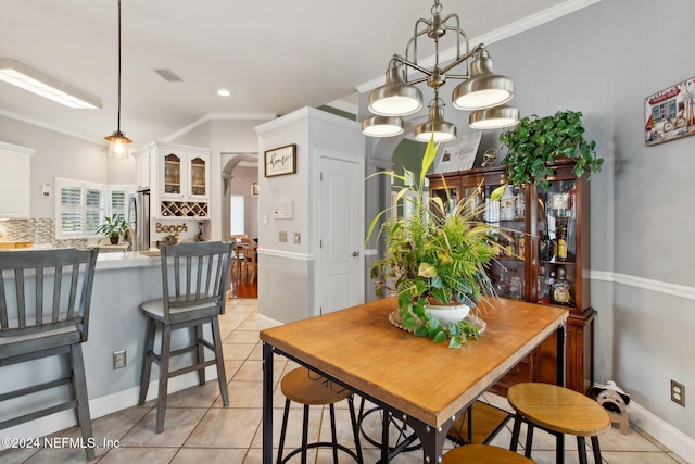 dining room featuring light tile patterned flooring, a notable chandelier, and ornamental molding