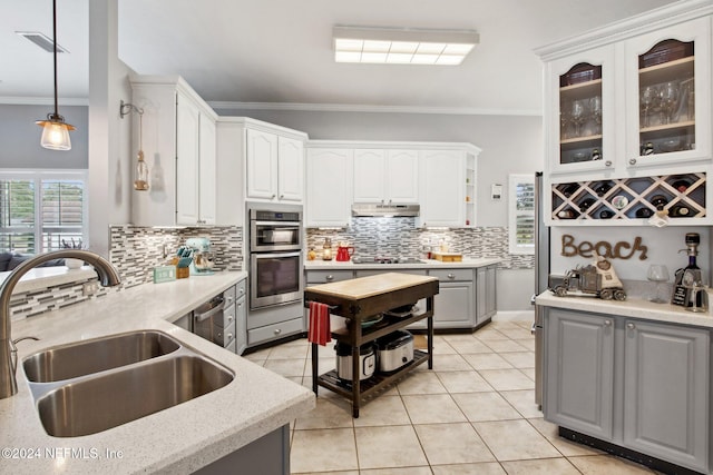 kitchen featuring white cabinets, hanging light fixtures, sink, and appliances with stainless steel finishes