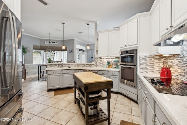 kitchen with white cabinetry, ornamental molding, hanging light fixtures, and appliances with stainless steel finishes