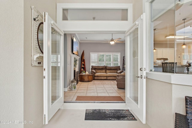 entryway featuring ceiling fan, french doors, light tile patterned flooring, and ornamental molding