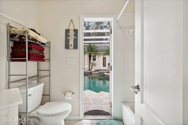 bathroom with toilet, tiled shower / bath combo, and tile patterned floors