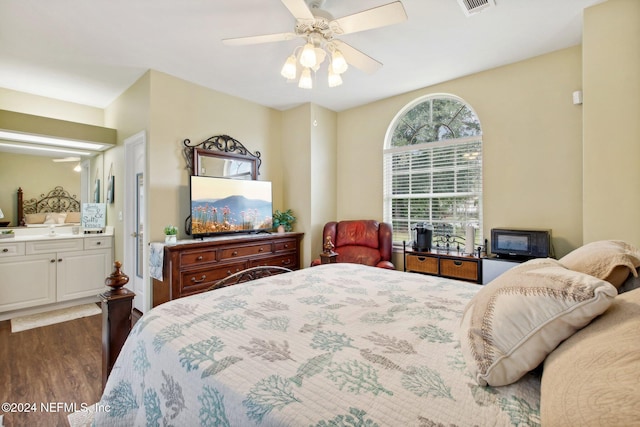 bedroom with ceiling fan, dark hardwood / wood-style flooring, and ensuite bath