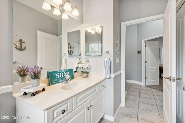 bathroom featuring tile patterned flooring, vanity, and an inviting chandelier