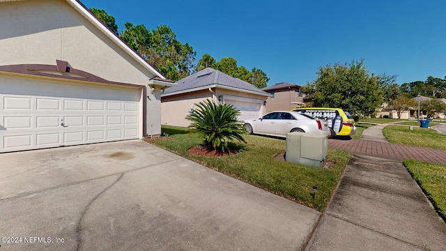 view of side of property featuring a lawn and a garage