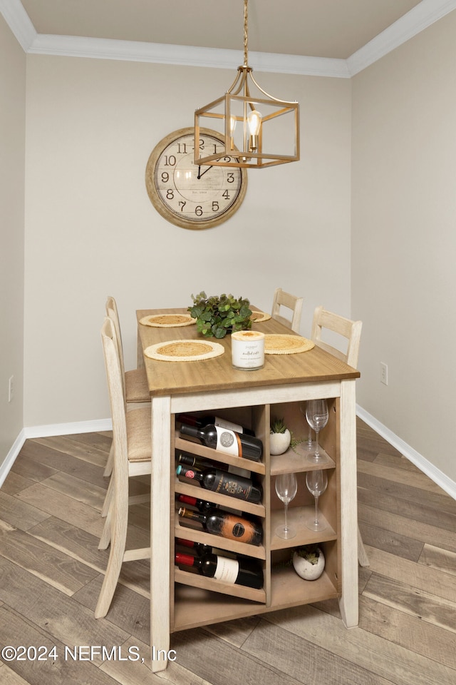 dining space featuring ornamental molding, hardwood / wood-style floors, and a chandelier