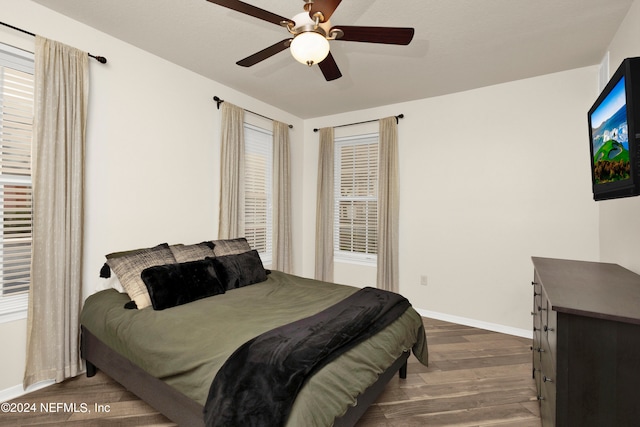 bedroom with dark hardwood / wood-style floors and ceiling fan