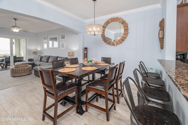 dining space featuring crown molding and ceiling fan with notable chandelier