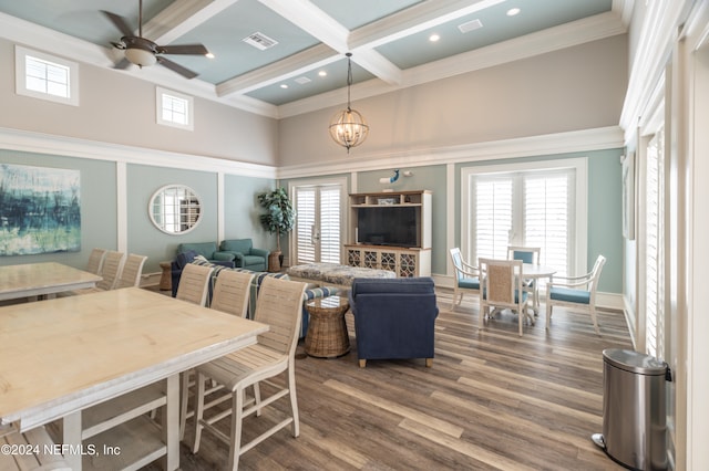 dining space with ceiling fan with notable chandelier, coffered ceiling, beam ceiling, ornamental molding, and dark hardwood / wood-style floors