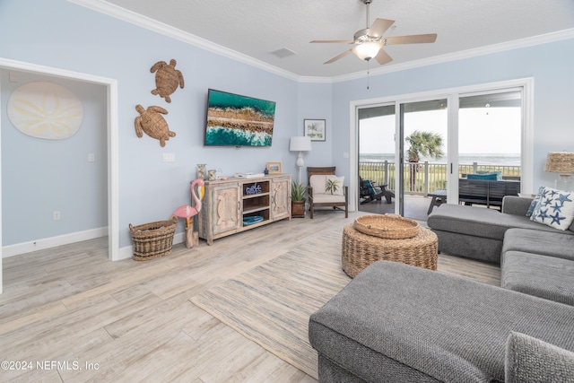 living area with crown molding, visible vents, wood finished floors, baseboards, and ceiling fan