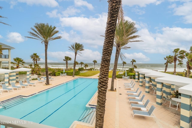 view of swimming pool with a patio and a water view