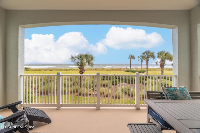 balcony featuring a beach view and a water view