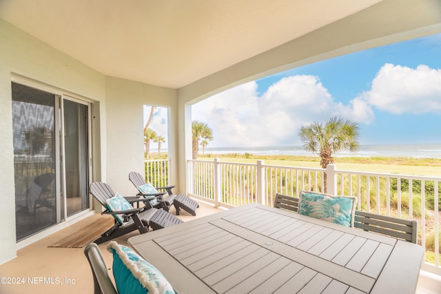 wooden terrace with a water view and a view of the beach