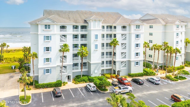 view of building exterior with a water view and uncovered parking