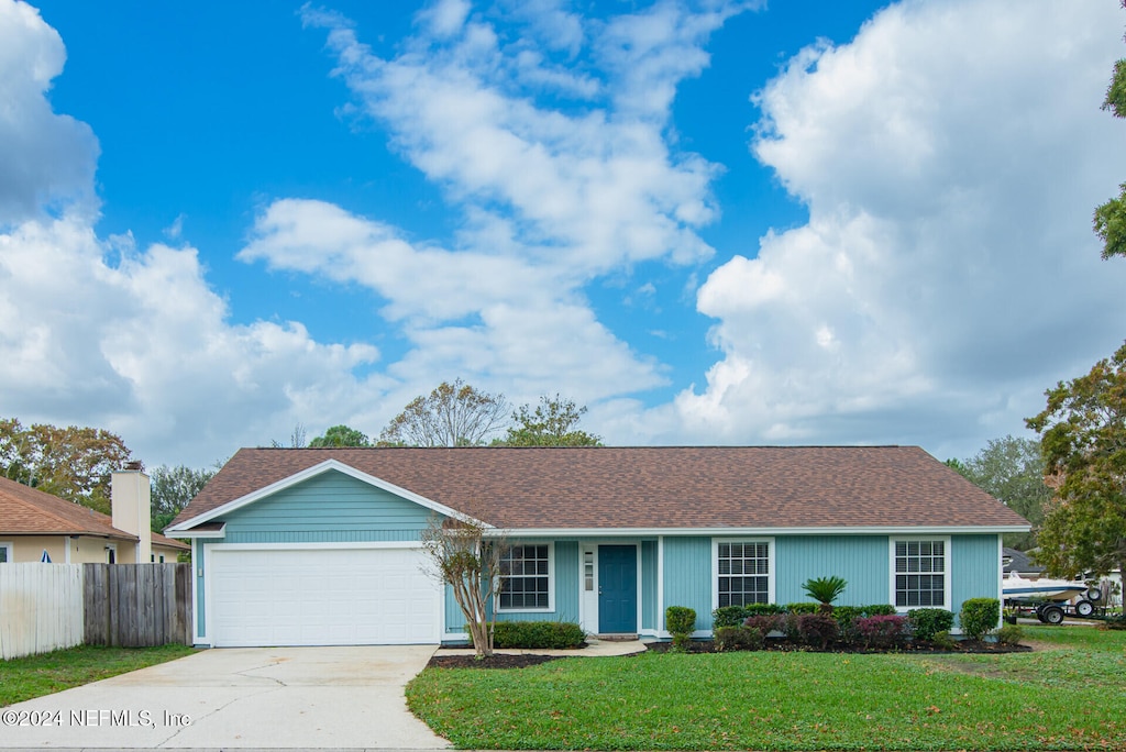 ranch-style house with a front yard and a garage