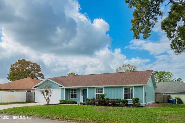 single story home featuring a garage and a front yard