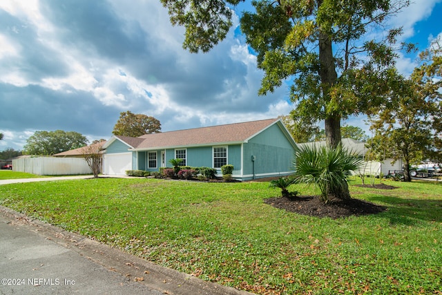 single story home featuring a garage and a front lawn