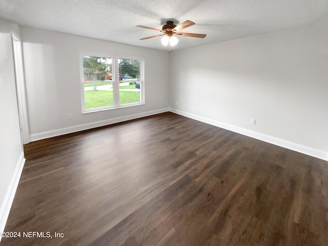 spare room with dark hardwood / wood-style floors, a textured ceiling, and ceiling fan