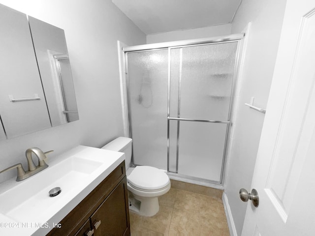 bathroom featuring vanity, tile patterned flooring, toilet, and an enclosed shower