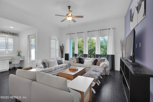 living room with ceiling fan, built in desk, and dark hardwood / wood-style flooring