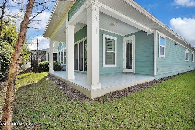 exterior space featuring covered porch and a lawn