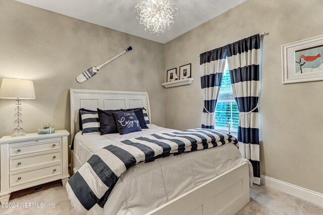 carpeted bedroom with an inviting chandelier