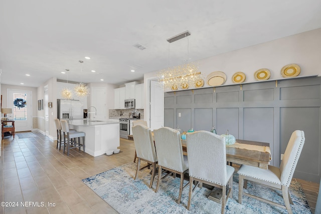 dining area with an inviting chandelier and sink