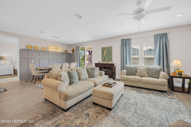 living room featuring ceiling fan and light hardwood / wood-style floors