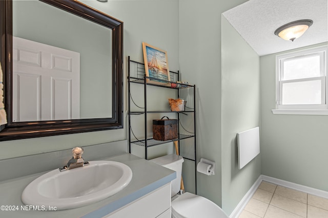 bathroom featuring vanity, tile patterned floors, a textured ceiling, and toilet