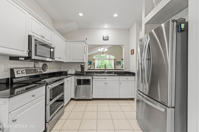 kitchen featuring an inviting chandelier, lofted ceiling, appliances with stainless steel finishes, and white cabinets