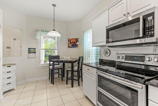 kitchen featuring white cabinets, stainless steel appliances, and light tile patterned floors