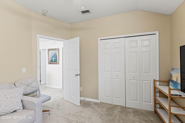 living area featuring a textured ceiling, vaulted ceiling, and light colored carpet