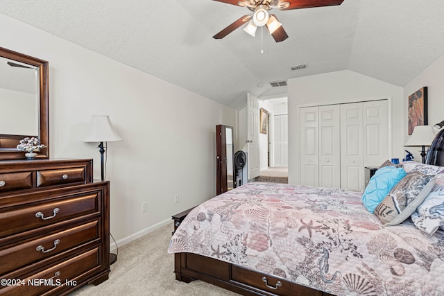 bedroom featuring a textured ceiling, a closet, ceiling fan, lofted ceiling, and light colored carpet