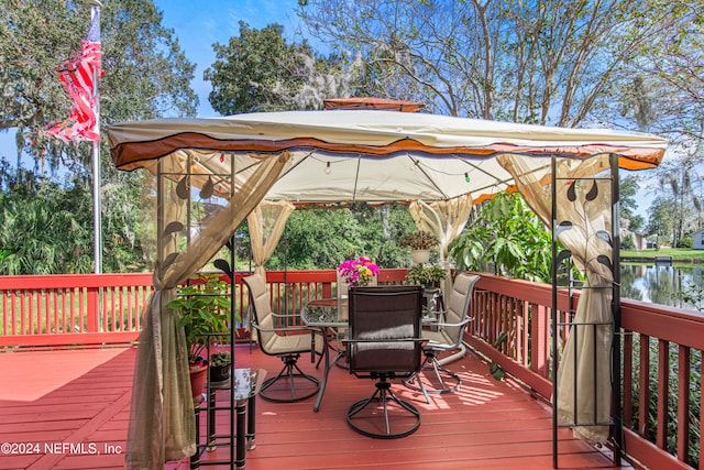 wooden terrace with a water view and a gazebo