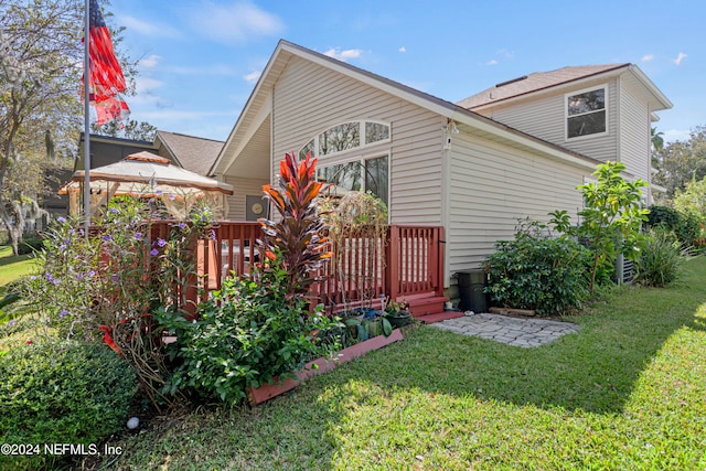 view of home's exterior featuring a wooden deck and a lawn