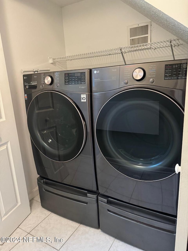 laundry room with tile patterned floors and washer and dryer