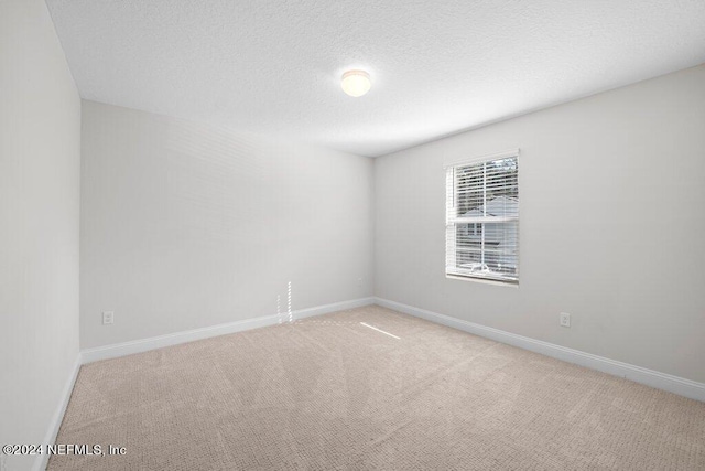 carpeted spare room featuring a textured ceiling