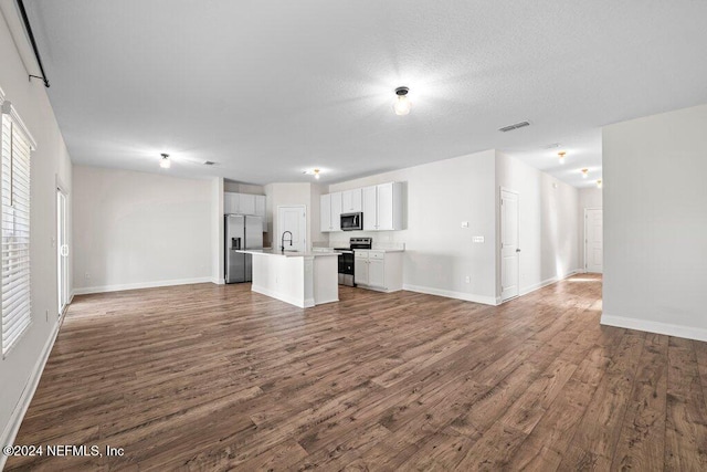 unfurnished living room with sink, dark hardwood / wood-style floors, and a textured ceiling