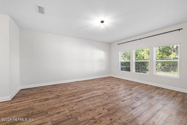 unfurnished room featuring hardwood / wood-style floors and a textured ceiling