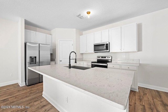 kitchen featuring white cabinets, a kitchen island with sink, stainless steel appliances, and sink