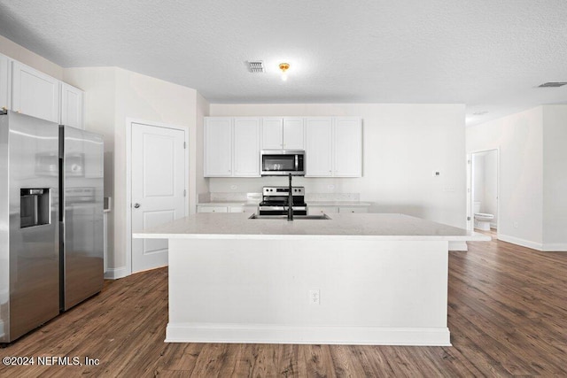 kitchen featuring white cabinets, a kitchen island with sink, dark hardwood / wood-style floors, sink, and stainless steel appliances