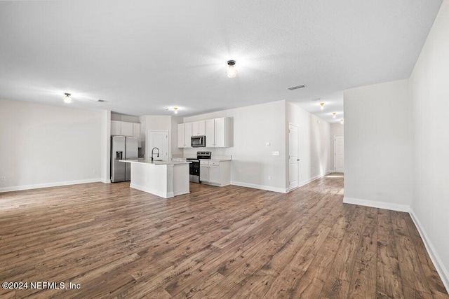 unfurnished living room featuring hardwood / wood-style floors and sink