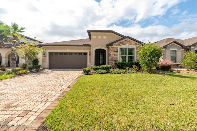 view of front of property with a front yard and a garage