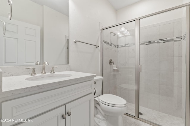 bathroom with a shower with door, vanity, and toilet