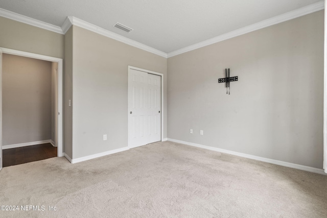 unfurnished bedroom featuring crown molding and light colored carpet