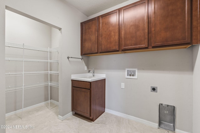 laundry room with cabinets, washer hookup, a textured ceiling, electric dryer hookup, and sink